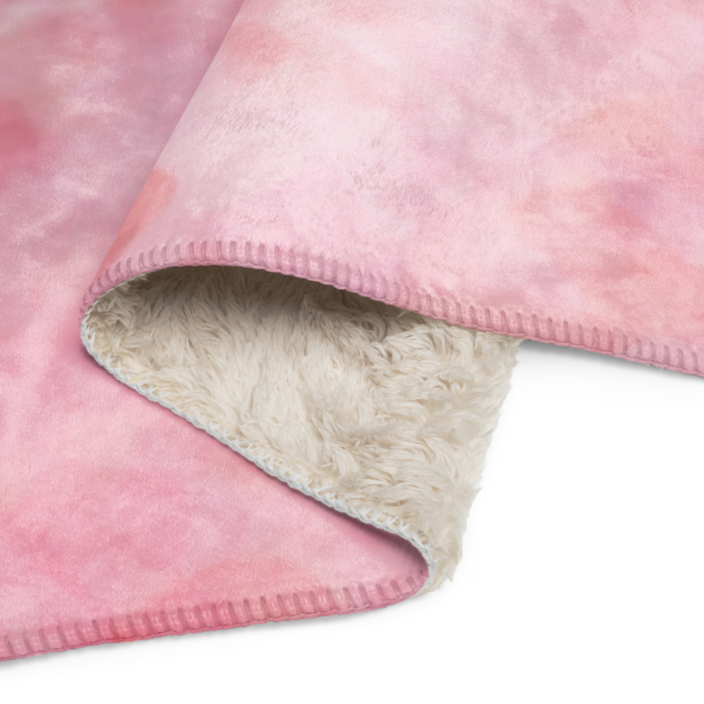 Close-up of a pink fleece blanket with a beige interior on a white background