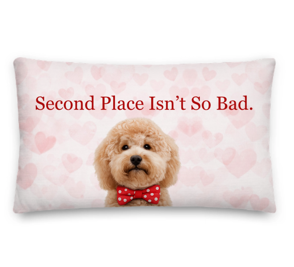Decorative pillow with a dog wearing a bow tie and text 'Second Place Isn't So Bad' on a heart-patterned background.