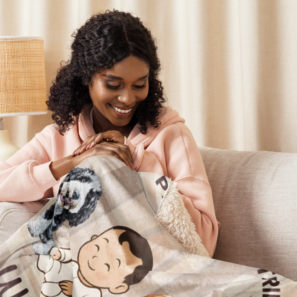 Woman sitting on a couch holding a blanket with cartoon characters, smiling.