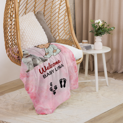 Pink baby blanket with personalized text on a wicker chair in a room setting.