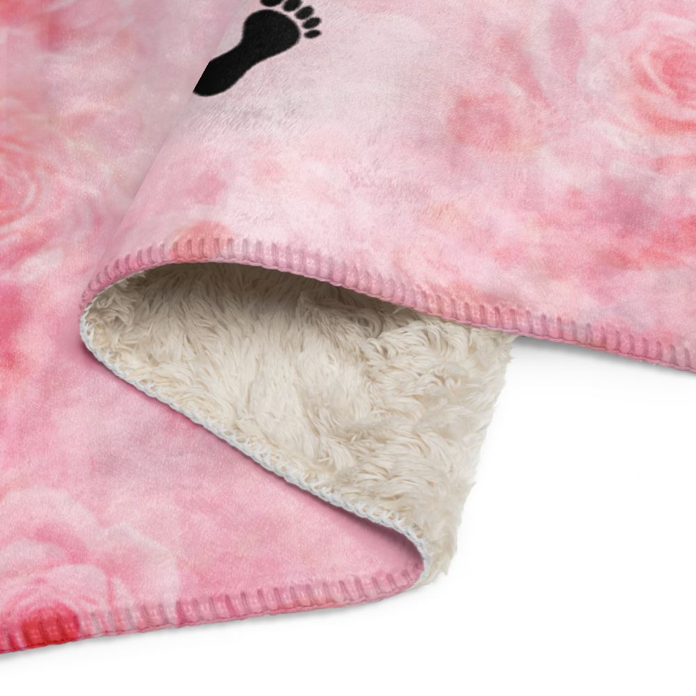 Pink fleece blanket with a black footprint logo on a white background