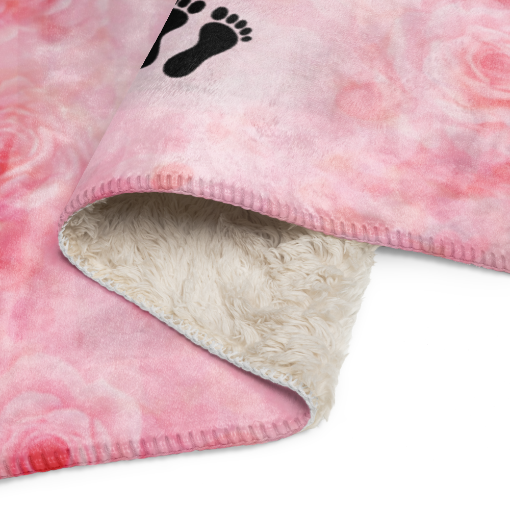 Pink fleece blanket with a black footprint logo on a white background