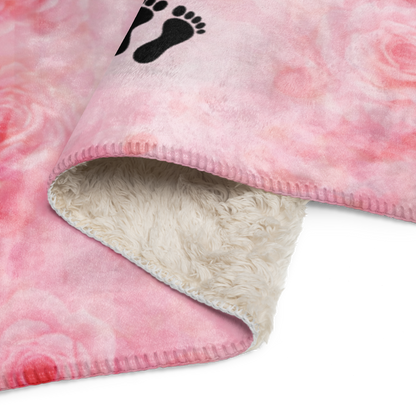 Pink fleece blanket with a black footprint logo on a white background